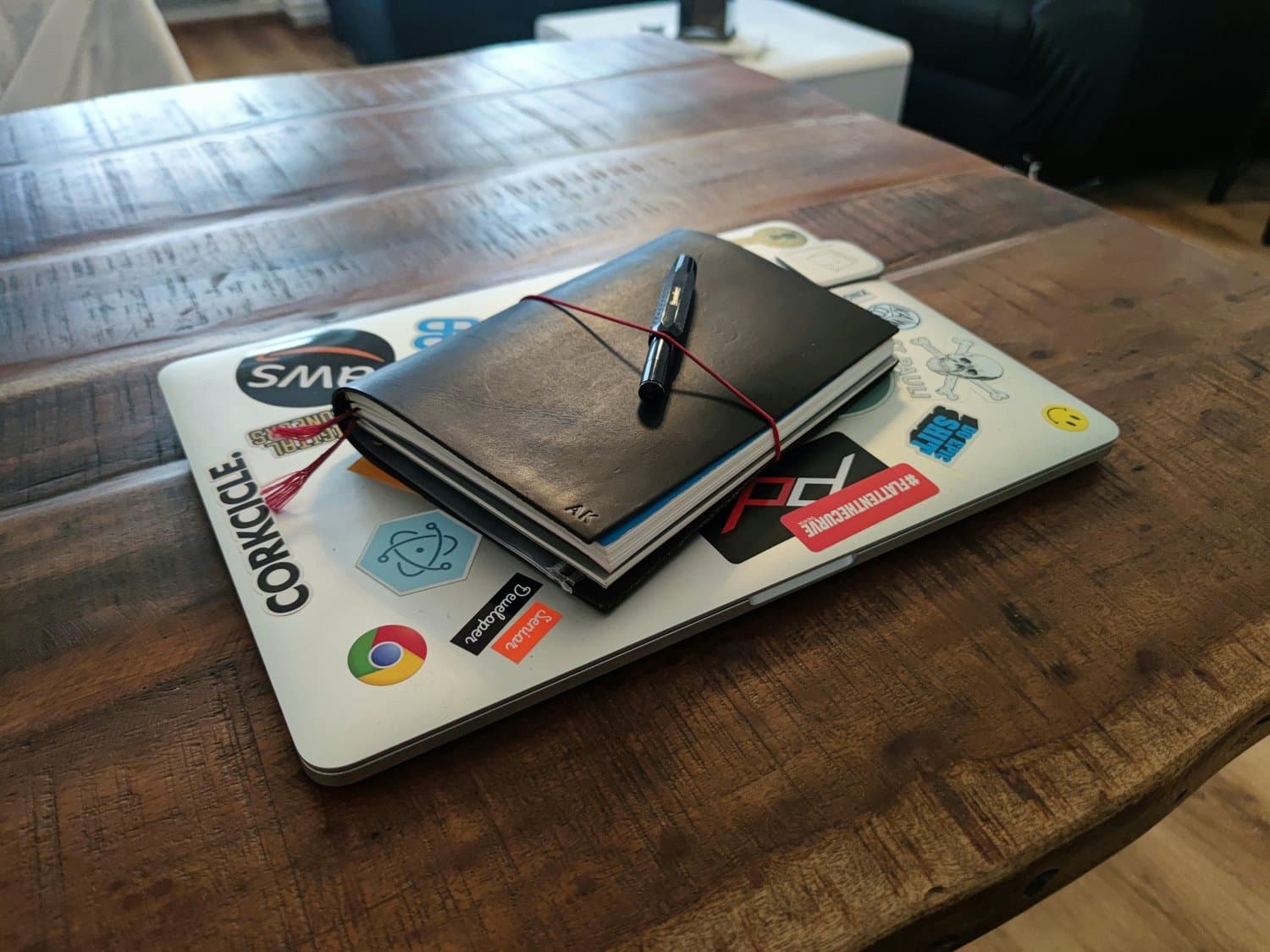 Ordinateur portable et carnets posés sur un bureau en bois