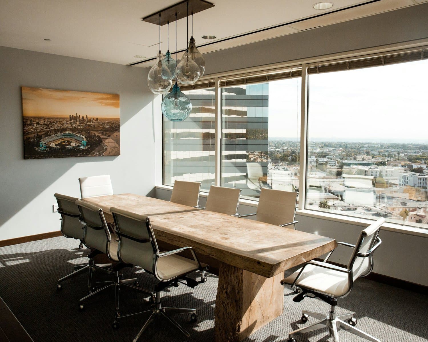 Salle de réunion avec grande table en bois et vue sur la ville