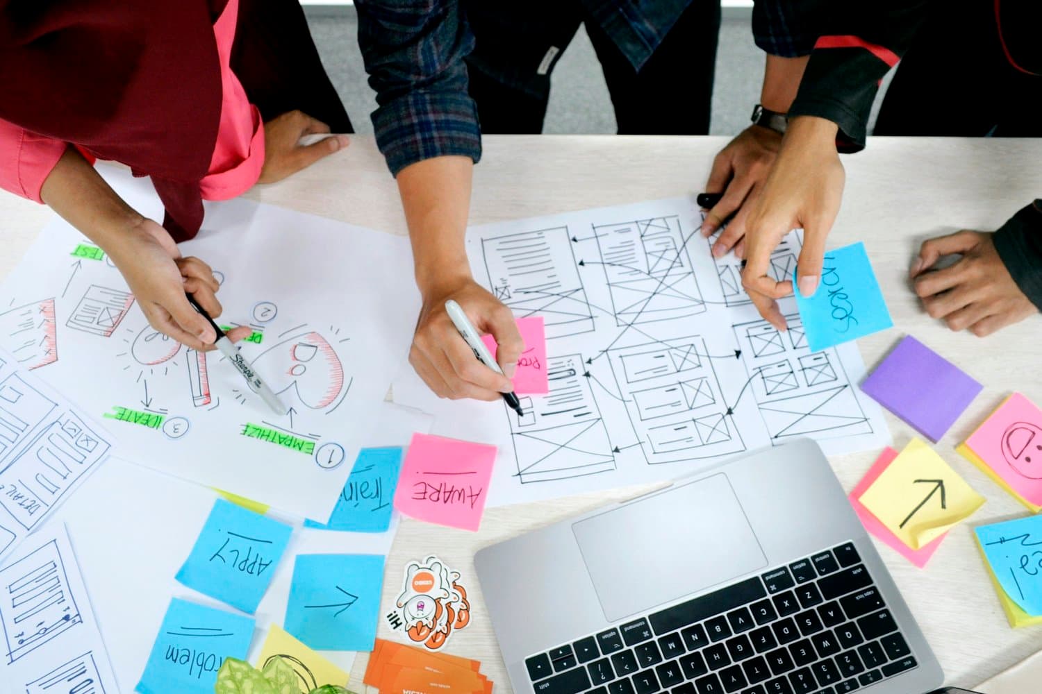 Équipe travaillant sur des maquettes produit avec post-its
