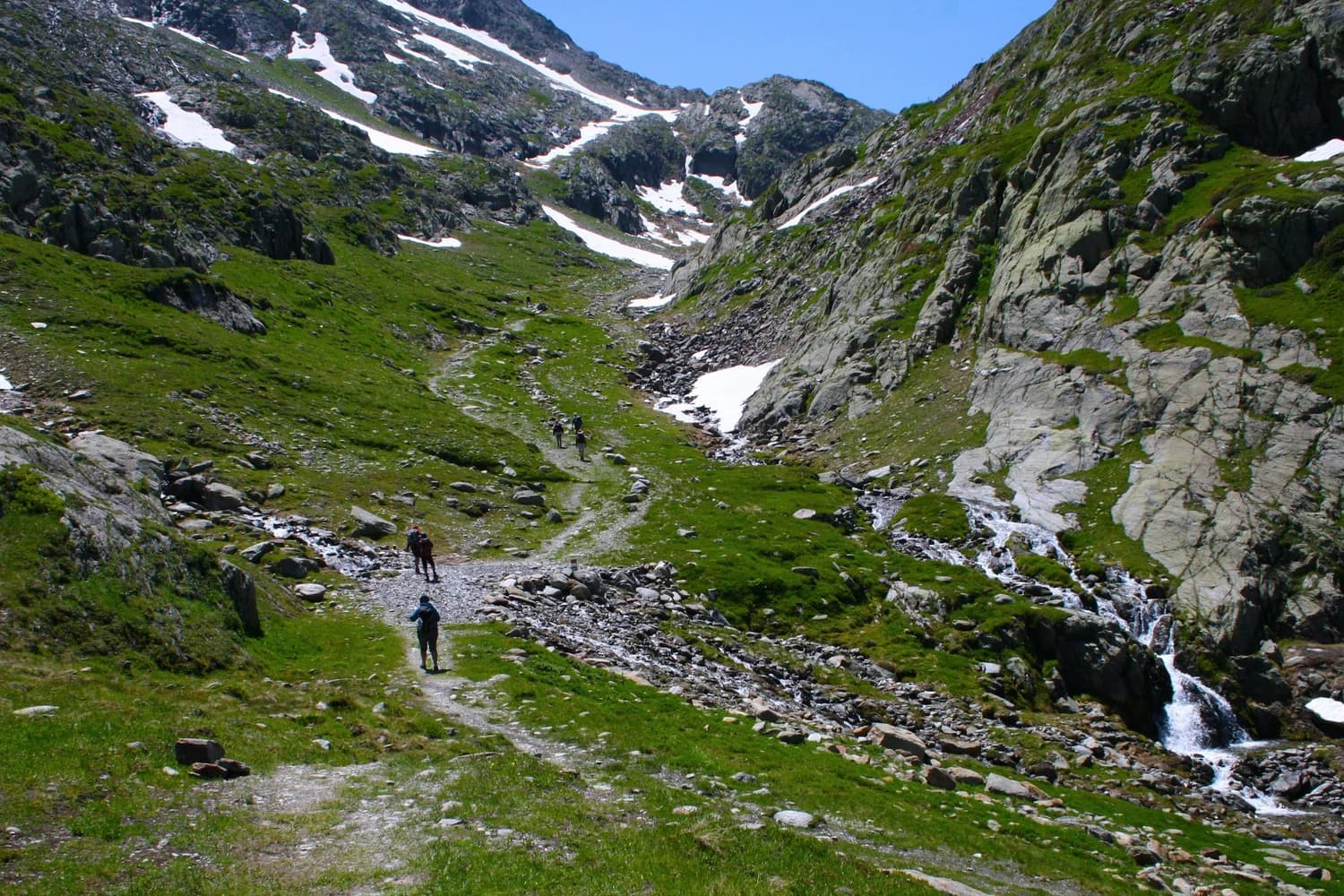 Marcheurs dans une vallée de montagne verdoyante